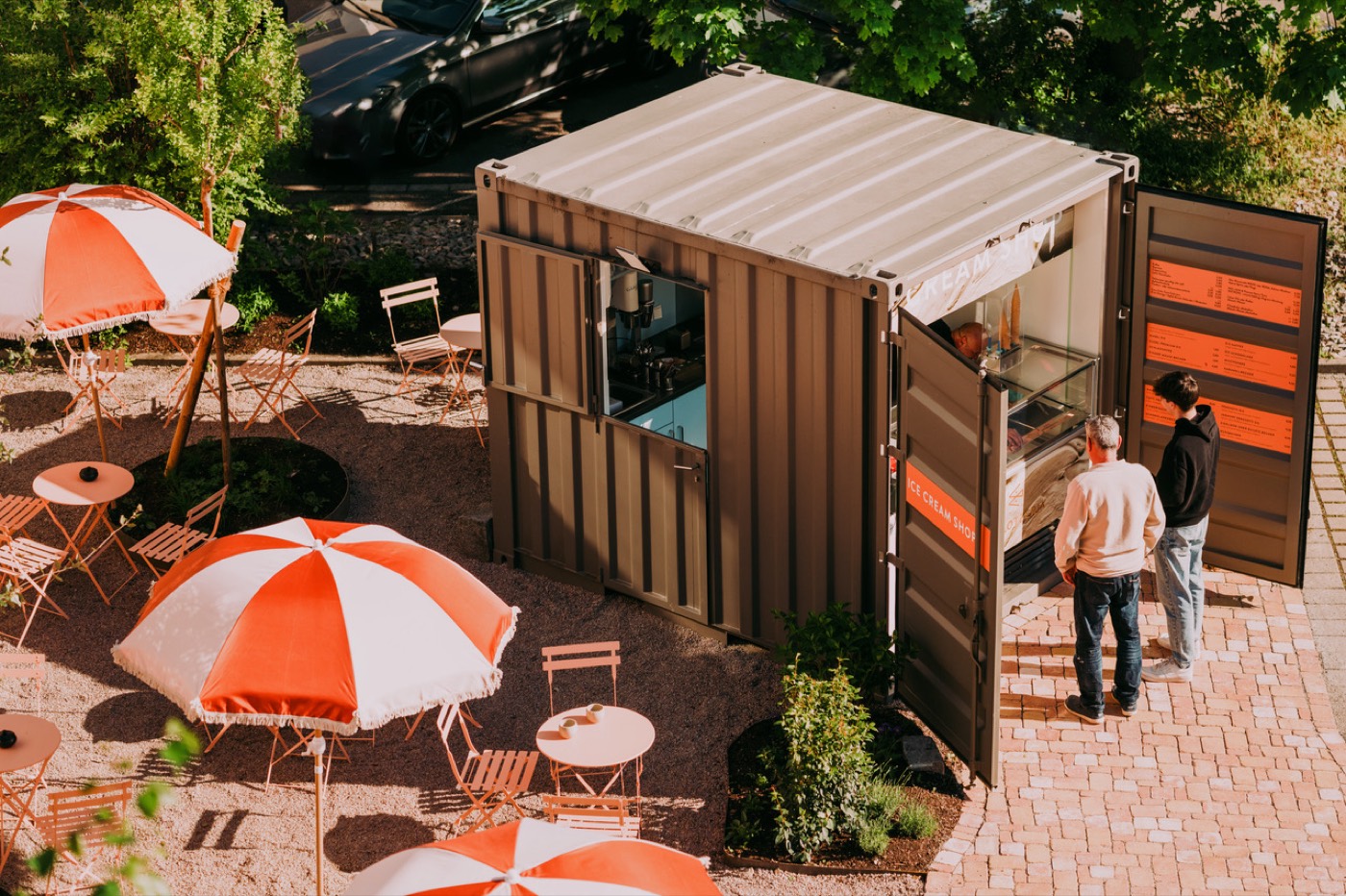 Schlotzeria Container-Shop am Hotel 2places in Lörrach-Stetten — Außenbereich mit Sonnenschirmen und Sitzplätzen