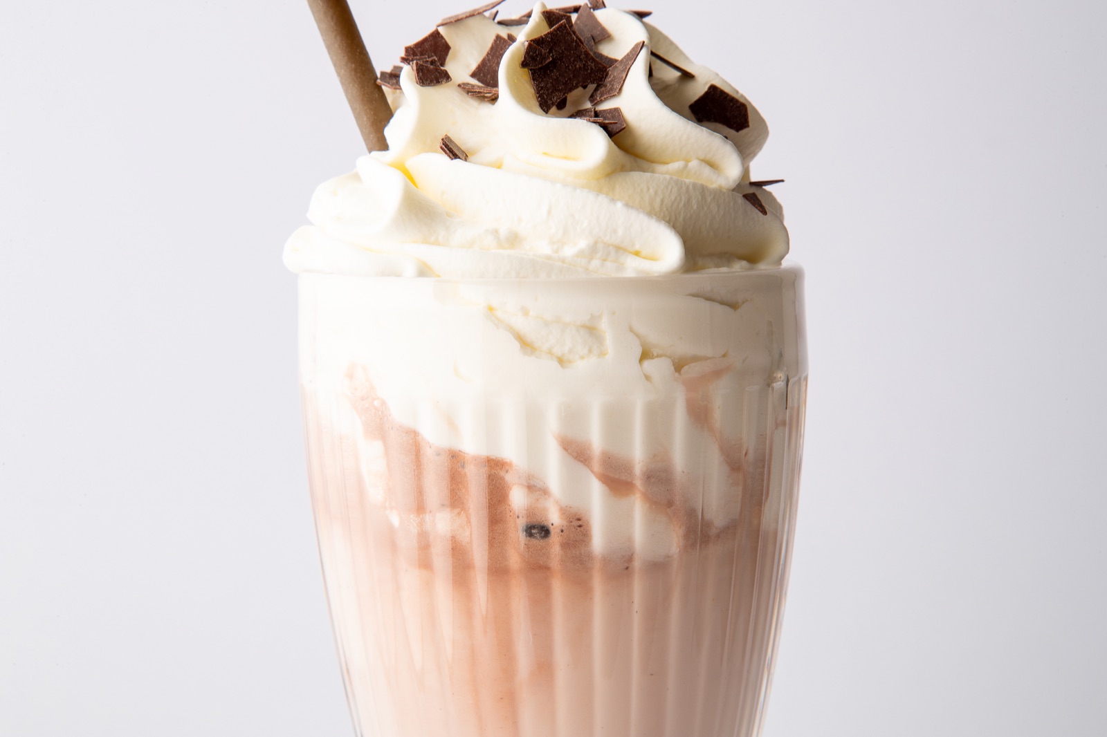 Eiskaffee mit Sahnehaube, Schokoraspeln und Strohhalm